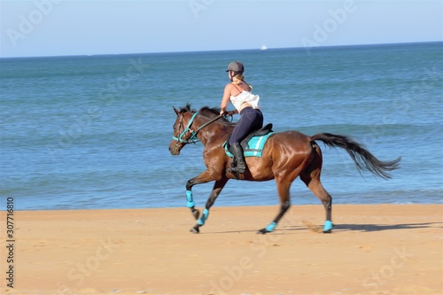 woman riding horse on the beach
