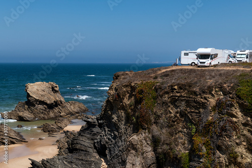 Campers parked on a cliff near the village of Porto Covo, in the Costa Vicentina Natural Park in Portugal; Concept for road trip in Portugal and summer vacations