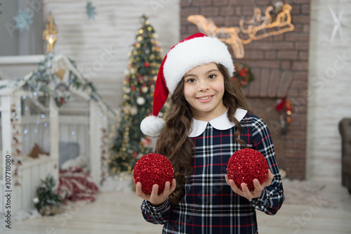Decor shop. Pick decorations home. Child decorating christmas tree balls. Girl kid decorating christmas tree. Kid santa hat decorating christmas tree. Cheerful kid. Decorating her favorite activity