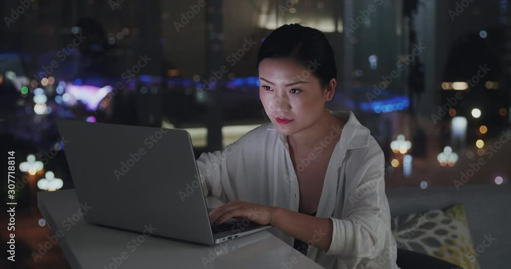 Close up of one young asian woman using laptop at home at night by the window female freelancer working late with laptop Close up of one young asian woman using laptop at home at night by the window female freelancer working late with laptop