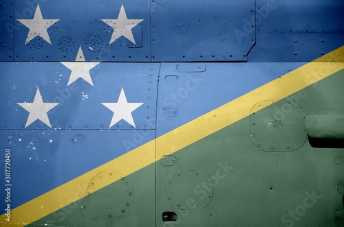 Solomon Islands flag depicted on side part of military armored helicopter closeup. Army forces aircraft conceptual background photo