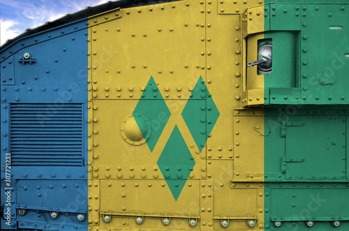 Saint Vincent and the Grenadines flag depicted on side part of military armored tank closeup. Army forces conceptual background photo