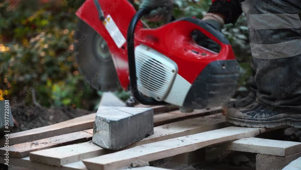 The worker turns on the tool after refueling the concrete cutter and flattens the heavy slab for the incision. 4k The worker turns on the tool after refueling the concrete cutter and flattens the heavy slab for the incision. 4k
