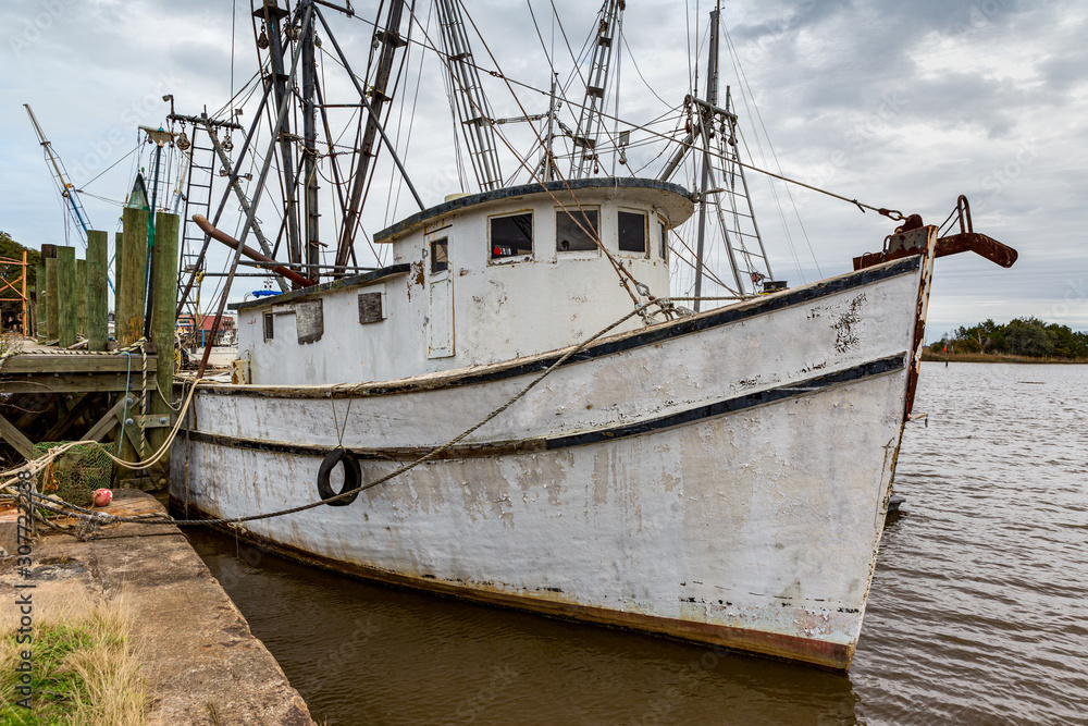 old white shrimp fishing boat at dock