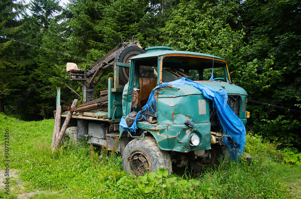 Old damaged car for transporting logs. Abandoned timber car in a village. Carpathian mountains, Ukraine.