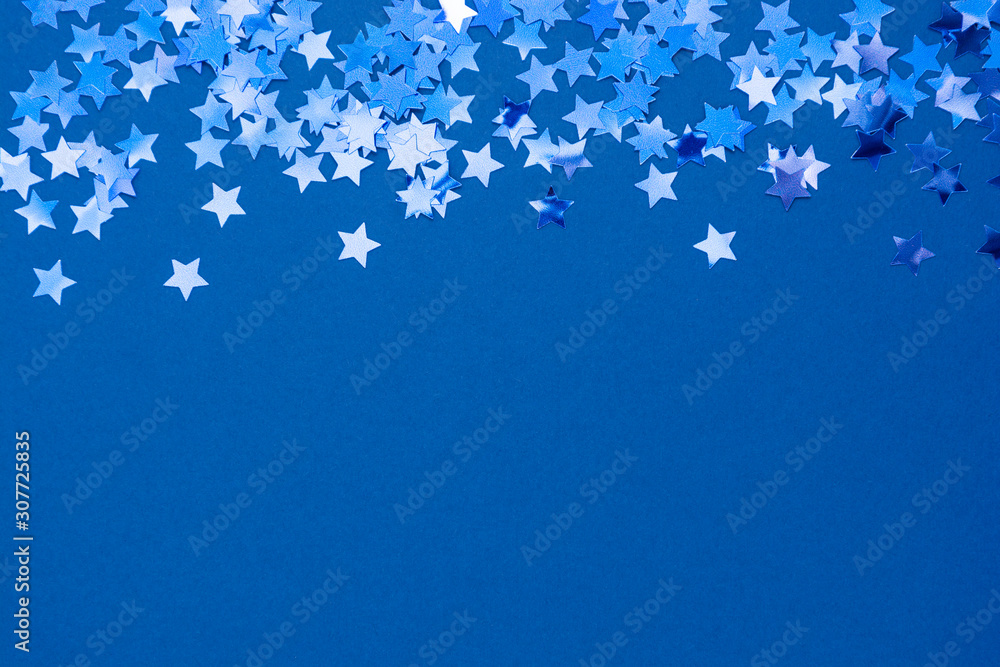 Blue abstract Christmas background or texture with stars confetti on blue background. Space for text. Blue abstract Christmas background or texture with stars confetti on blue background. Space for text.