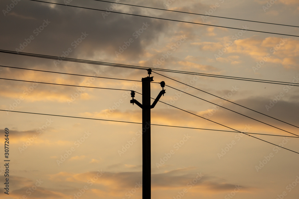 View of electricity pole with silhouette effect during the sunset View of electricity pole with silhouette effect during the sunset