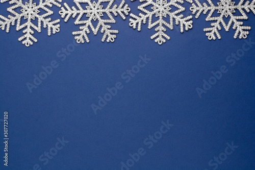 Blue abstract Christmas background with silver snowflakes winter decoration, blue mock up with space for text.