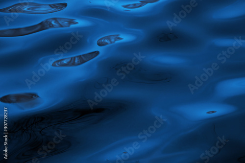 Water surface with reflections in cityscape. Classic blue - trend color of 2020