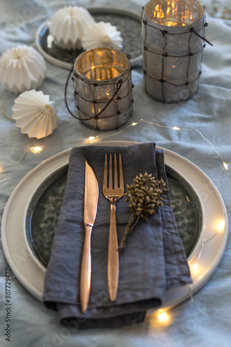 Christmas table setting with stoneware ceramic plates and origami decorations