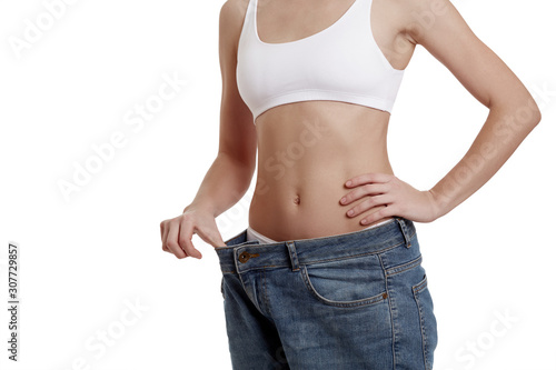Perfect, slim, young body of a girl in white underwear. Weight loss and healthy eating. A woman in jeans of large size. The problem of obesity. Plastic surgery.