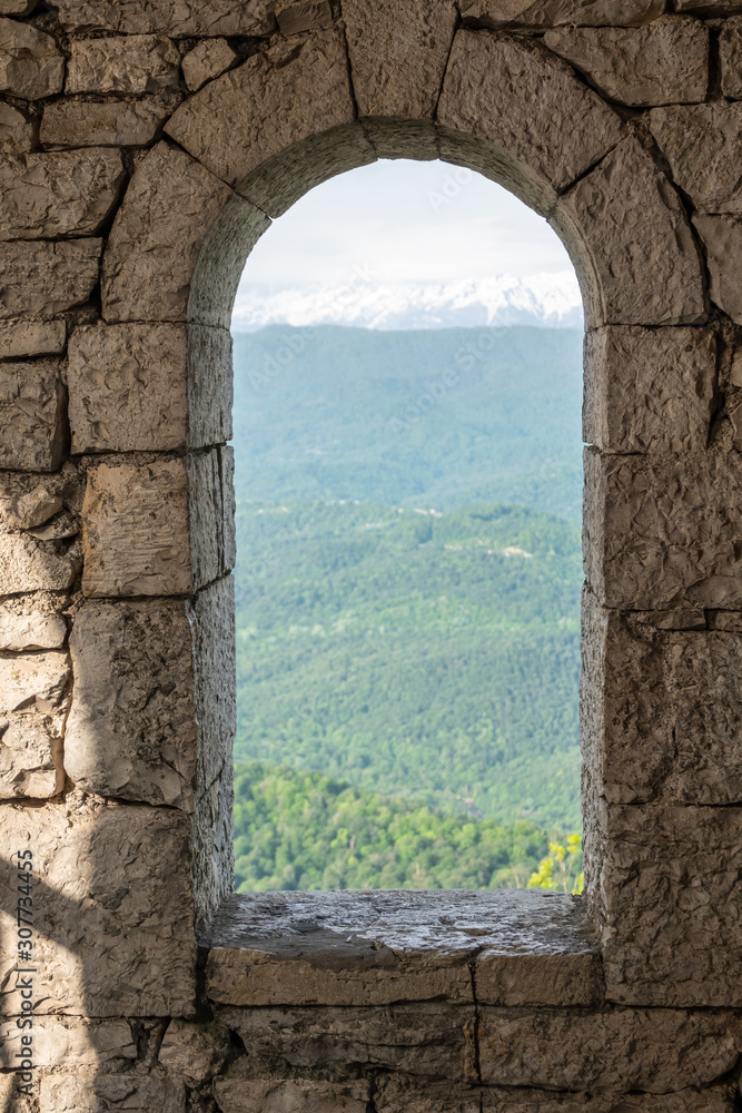 A narrow window in an old tower or fortress, view from the inside.