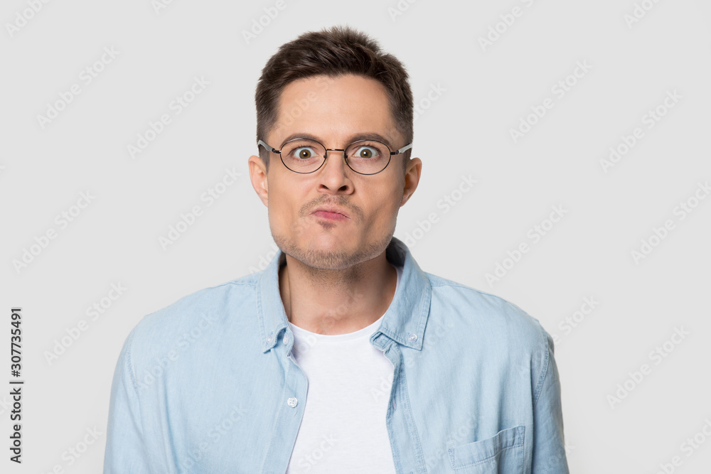 Headshot of confused angry man in eyeglasses looking at camera Headshot of confused angry man in eyeglasses looking at camera