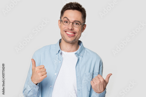 Young man with funny nerd jerk face showing thumb up