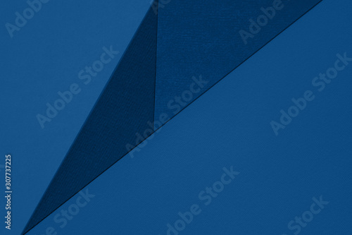 Abstract trendy classic blue paper background with copy space for text. Diagonal geometric composition. Top view, flat lay. Color of the year 2020trend concept 