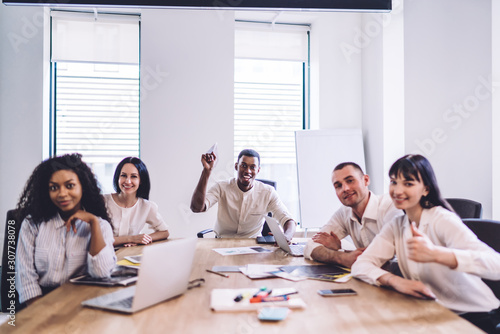 Multiracial team of joyful employees having fun in office