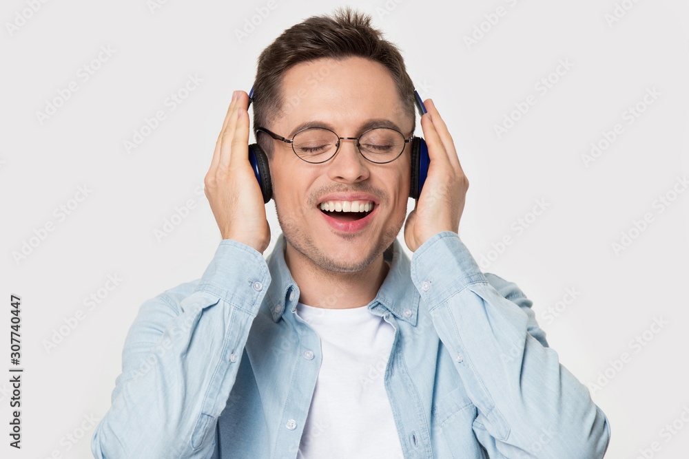 Overjoyed happy guy in eyeglasses enjoying favorite music. Overjoyed happy guy in eyeglasses enjoying favorite music.