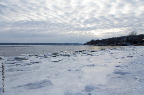 View of sheets of ice on the Cap-Rouge bay beach with altocumulus clouds in the sky during a winter late afternoon, Quebec City, Quebec, Canada