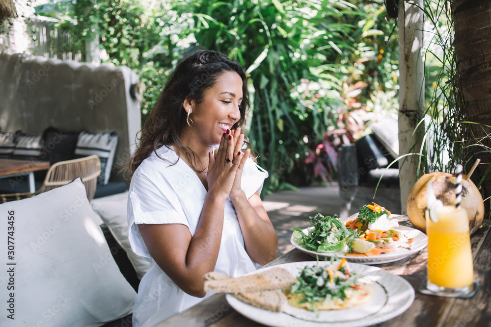 Pleasantly surprised ethnic woman looking at food