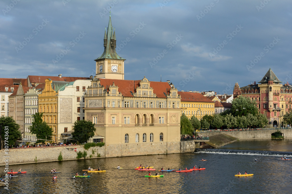 Panorama of the Vltava embankment with beautiful colorful houses from a pleasure boat. Summer evening before a thunderstorm. Prague 1. Vltava river with pleasure boats.