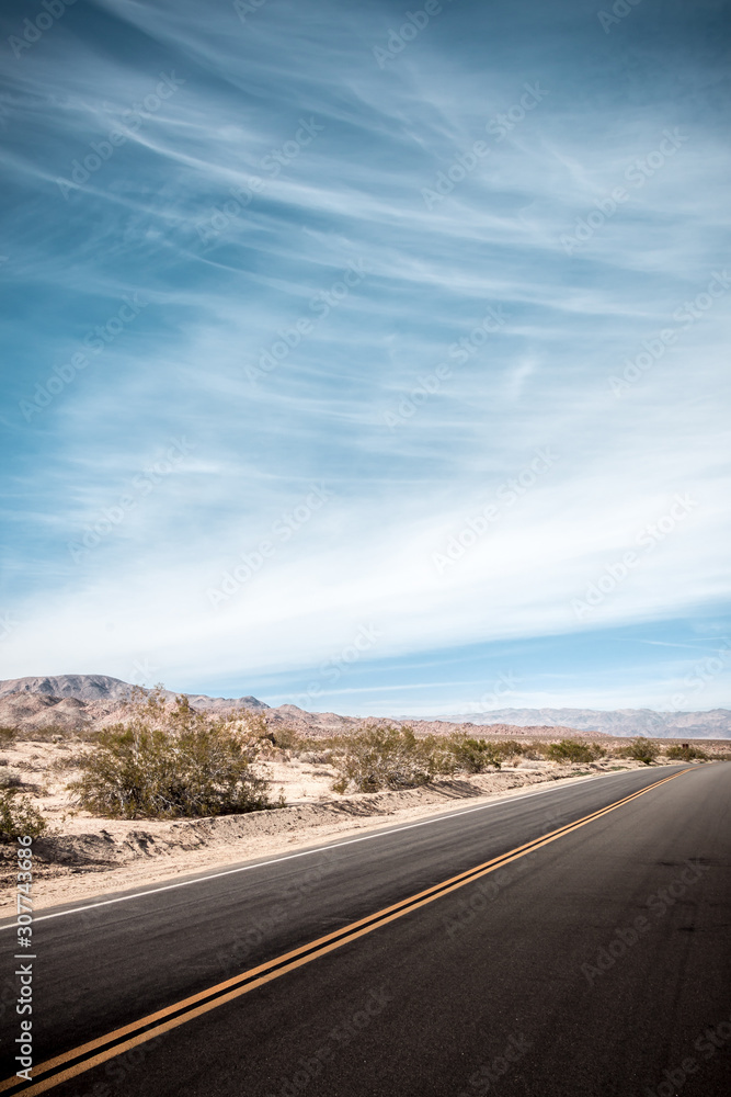 Naklejka premium Blue sky over the desolate desert road