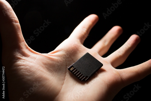 SD card in hand on a dark background