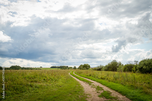 road, field and cloudy sky