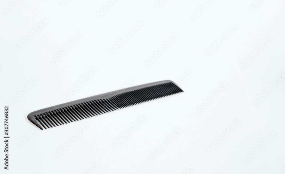 Black hair comb on a light background. Fashion and beauty concept. Black hair comb on a light background. Fashion and beauty concept.