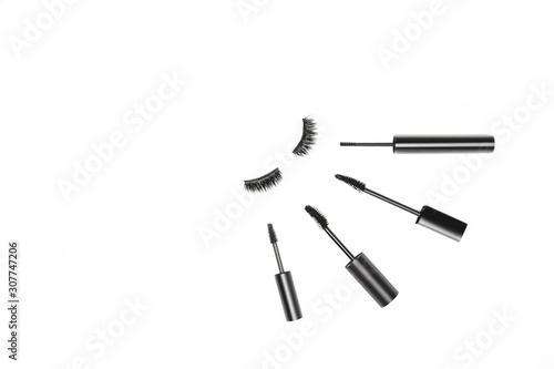 Basic product for eye makeup. Types mascara in black tube, long fake magnetic hairs lashes on white backdrop. Beauty blog concept, minimalistic idea. Eyelash extension. Copy space