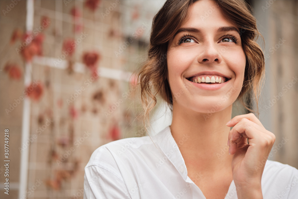 Portrait of young beautiful smiling woman joyfully looking away in modern workshop Portrait of young beautiful smiling woman joyfully looking away in modern workshop