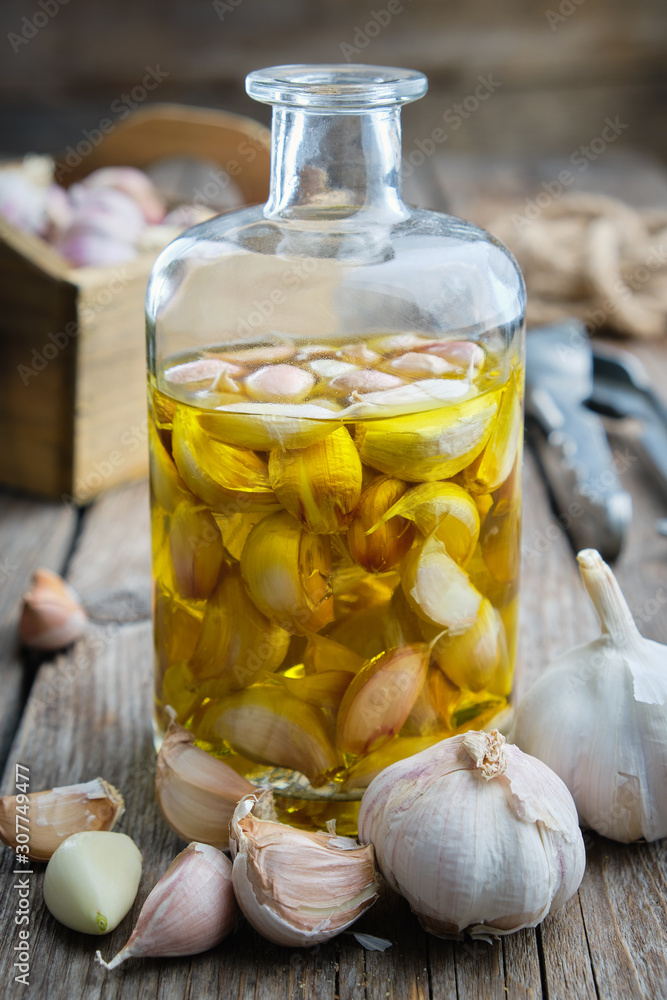 Garlic aromatic flavored oil or infusion bottle and garlic cloves. Garlic aromatic flavored oil or infusion bottle and garlic cloves.