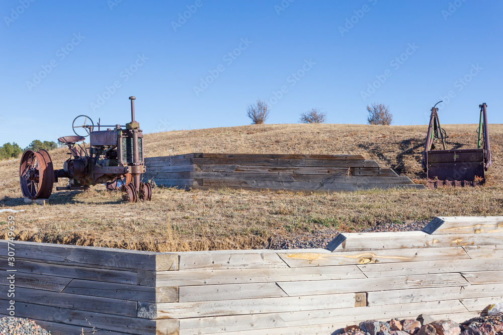 Fototapeta premium Old tractor and farm implement in a prairie setting