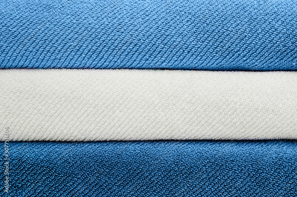 Fototapeta premium Stack of blue and whit towels. Copy space for text