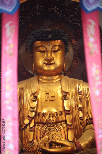 Buddha with the symbol of the swastikaIn.  Buddhism, the swastika is considered to symbolize the auspicious footprints of the Buddha. It is an aniconic symbol for the Buddha in many parts of Asia photo