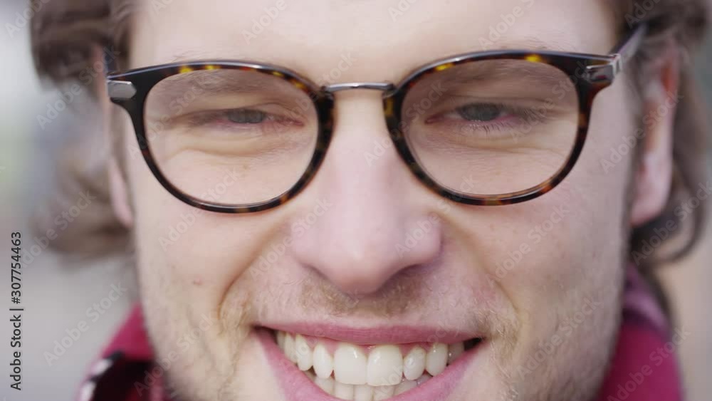 Portrait of handsome male in glasses looking and smiling to camera Portrait of handsome male in glasses looking and smiling to camera