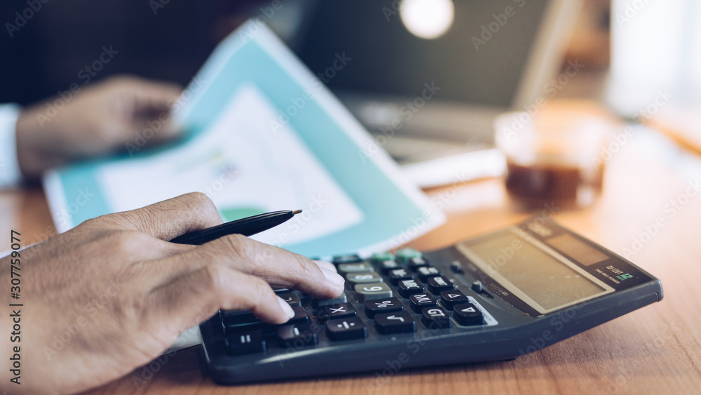 Business man using calculator and analysis on data paper Business man using calculator and analysis on data paper