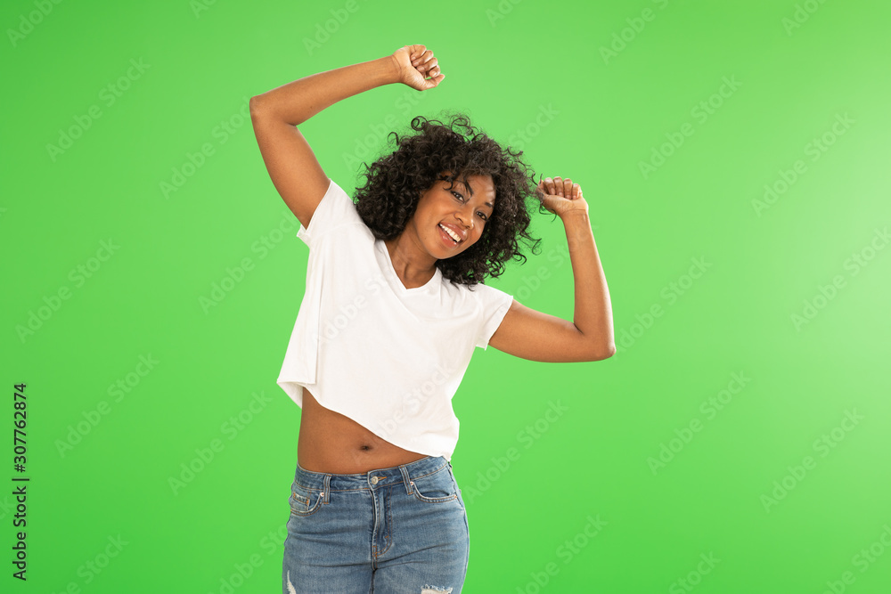 Happy and attractive Black girl in denim jeans smiling at camera Happy and attractive Black girl in denim jeans smiling at camera