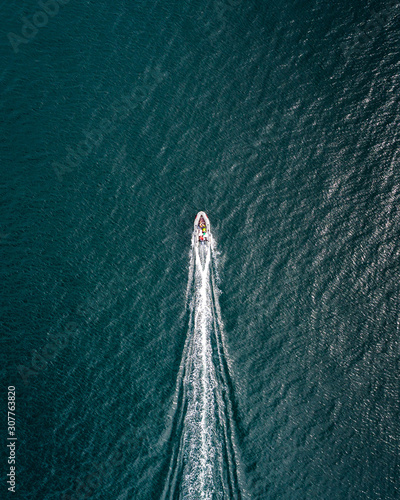 Slika na platnu Birds-eye view of boat flying through frame