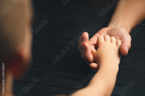 Adult hands holding kid hands © alexxndr