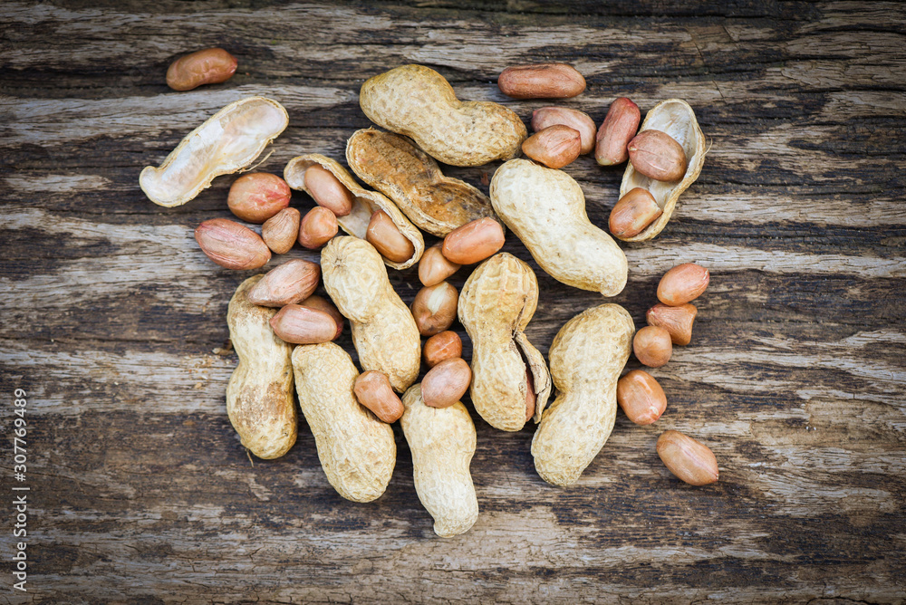 Obraz premium Peanut in shells for food or snack / Roasted peanuts on rustic wood background