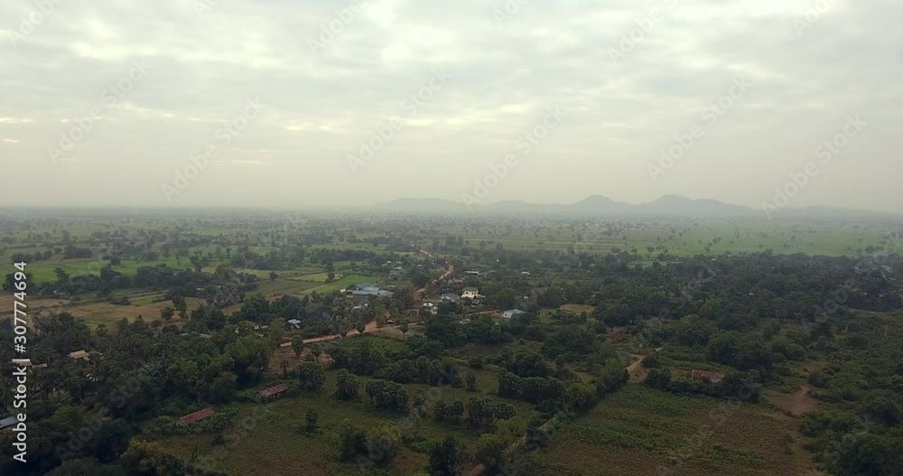 aerial shot of sunbeams on rice paddy fields and asian villages aerial shot of sunbeams on rice paddy fields and asian villages