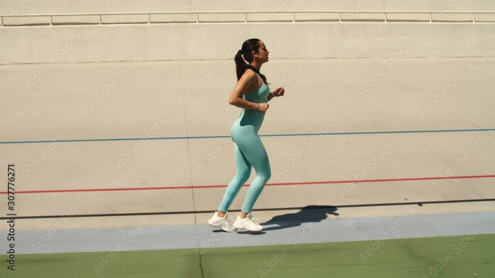 Woman runner running on racetrack. Fit woman training run workout Woman runner running on racetrack. Fit woman training run workout