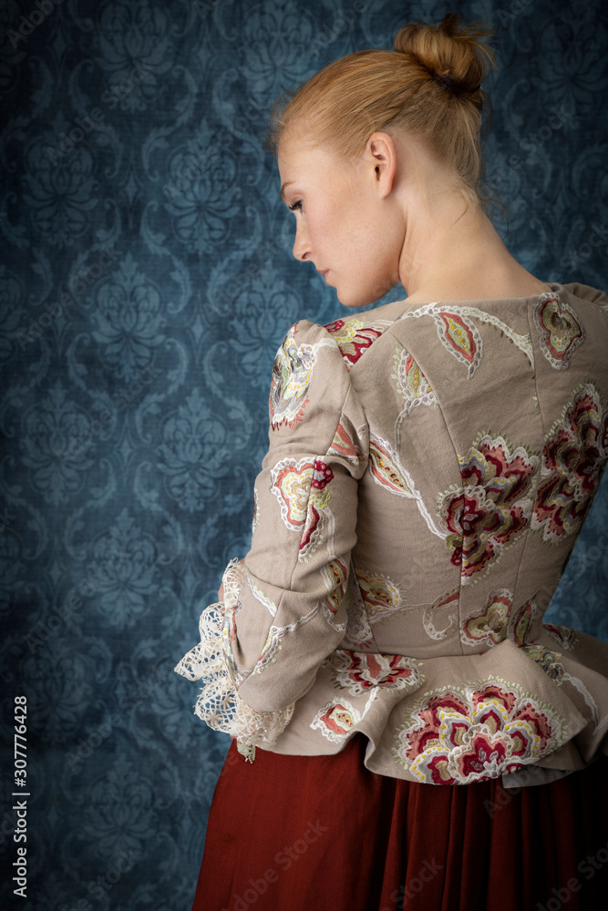 Red-haired 18th century woman wearing an embroidered bodice