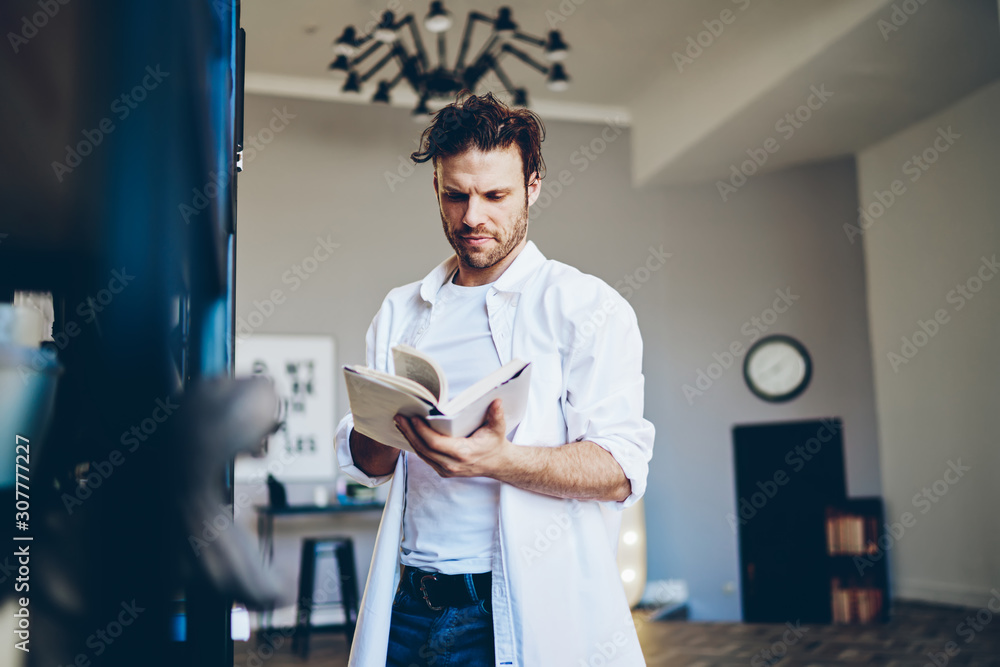 Fototapeta premium Focused man reading in living room
