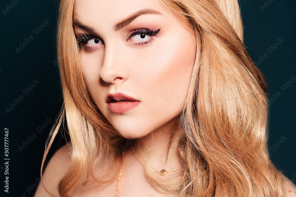 Blonde with long hair looking at the camera. Professional makeup, beautiful eyebrows, white lenses. Looking vampires, bright eyes. Hair care. Blindinka on a black back Blonde with long hair looking at the camera. Professional makeup, beautiful eyebrows, white lenses. Looking vampires, bright eyes. Hair care. Blindinka on a black back