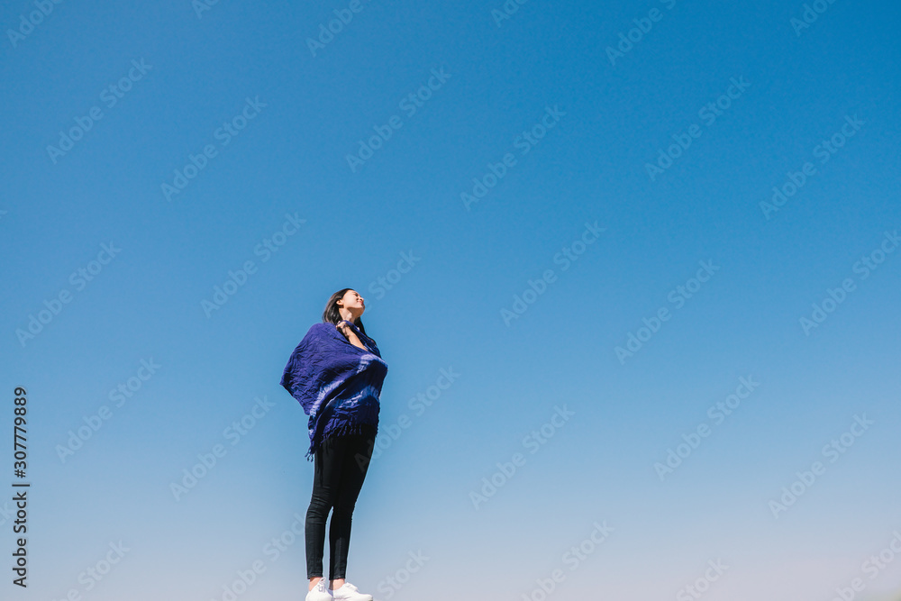 Happy woman with tanned slim body breathing fresh air raising her arms up, enjoying a sunny summer holiday on beach destination against blue sky, outdoors. Travel and well being lifestyle. Happy woman with tanned slim body breathing fresh air raising her arms up, enjoying a sunny summer holiday on beach destination against blue sky, outdoors. Travel and well being lifestyle.