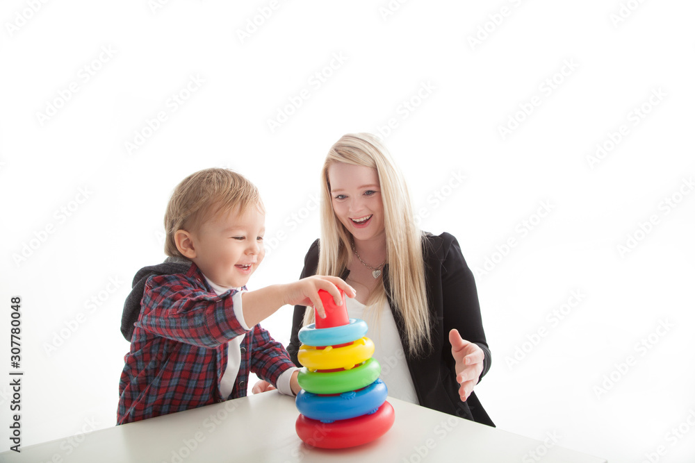 mother and son playing with ring stacking toy on white background