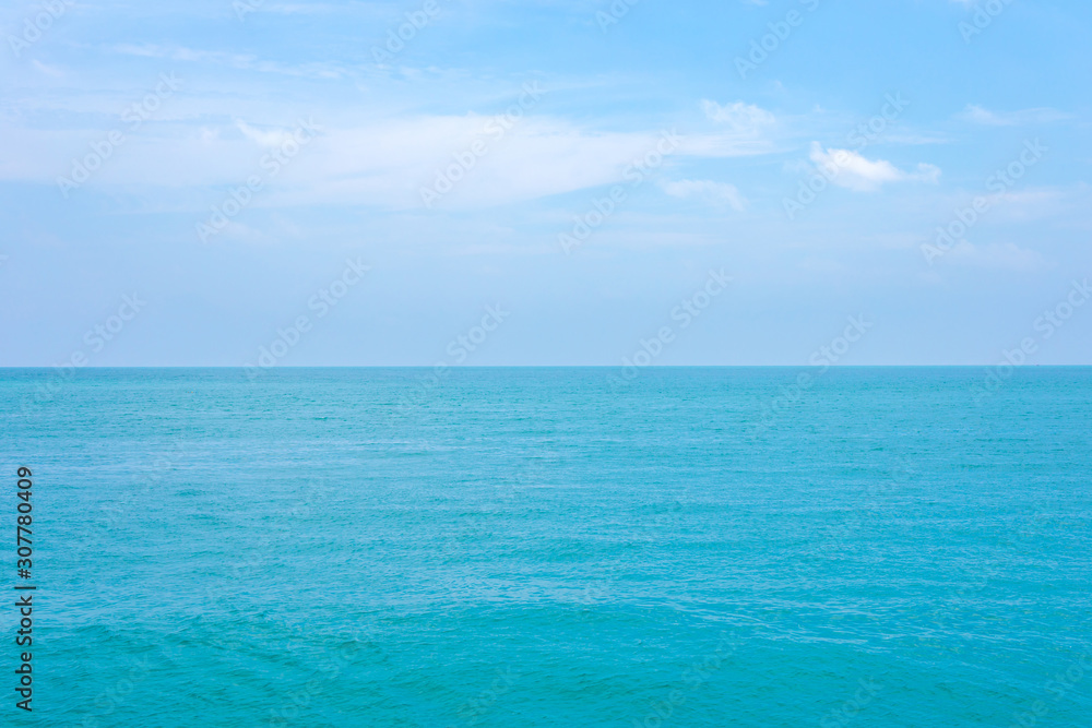 Clean blue sea water or ocean and clear blue sky and white clouds.