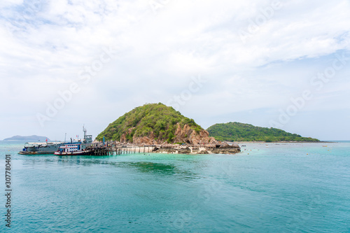 Panorama photo of Boat or ship at dock of Koh Kam island with green water sea and mountain forest Chonburi, Thailand.