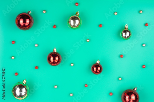 Christmas holidays composition, top view of red Christmas decorations on green background with copy space for text. Flat lay, winter, pattern,  postcard template, new year concept.